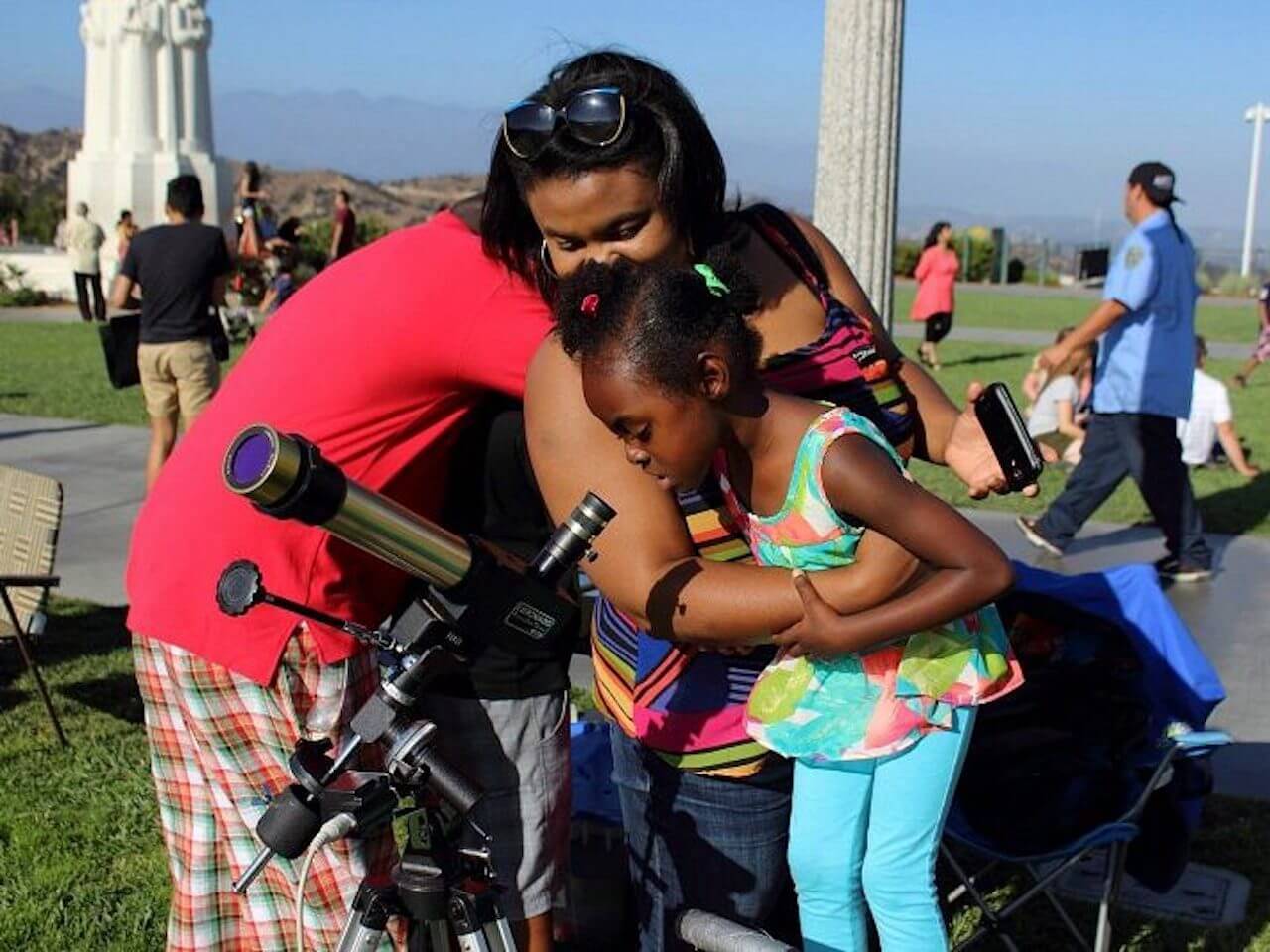 Mother and child looking through telescope on Griffith Park Observatory lawn